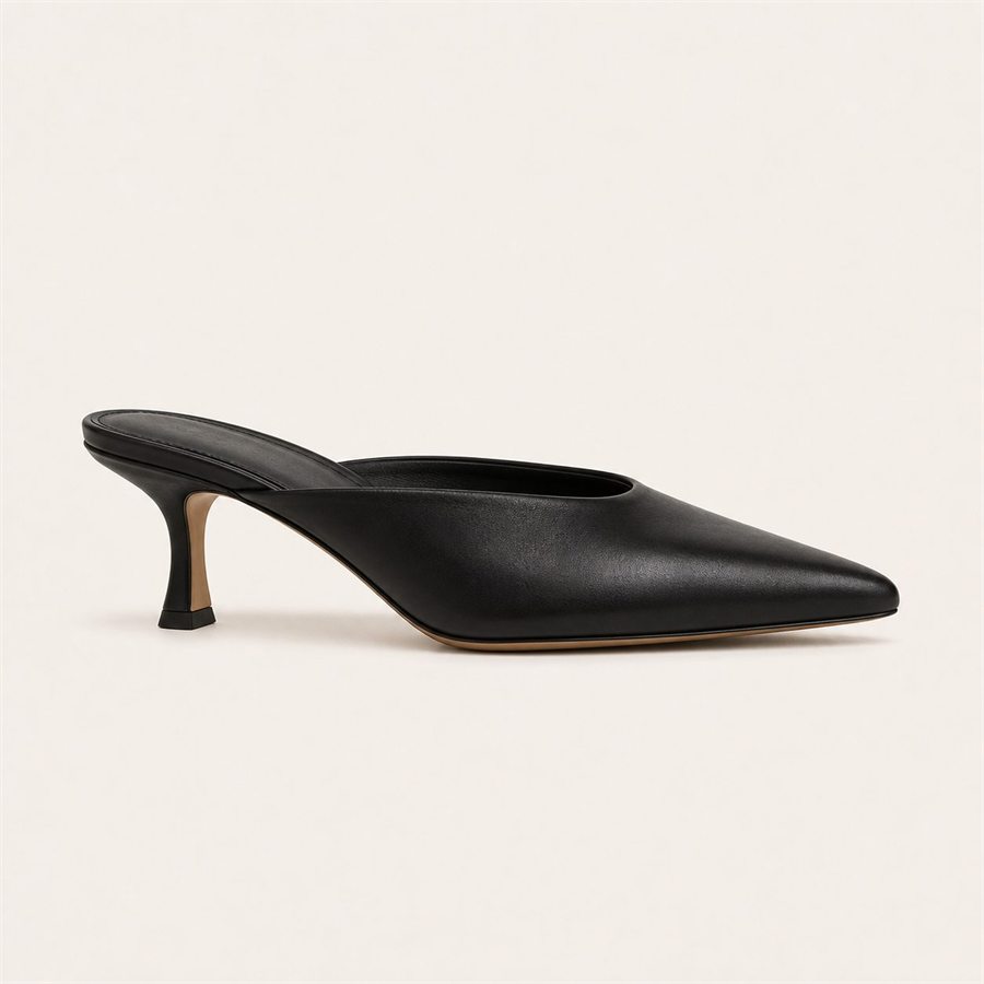 Black leather mule heel on a warm off-white background