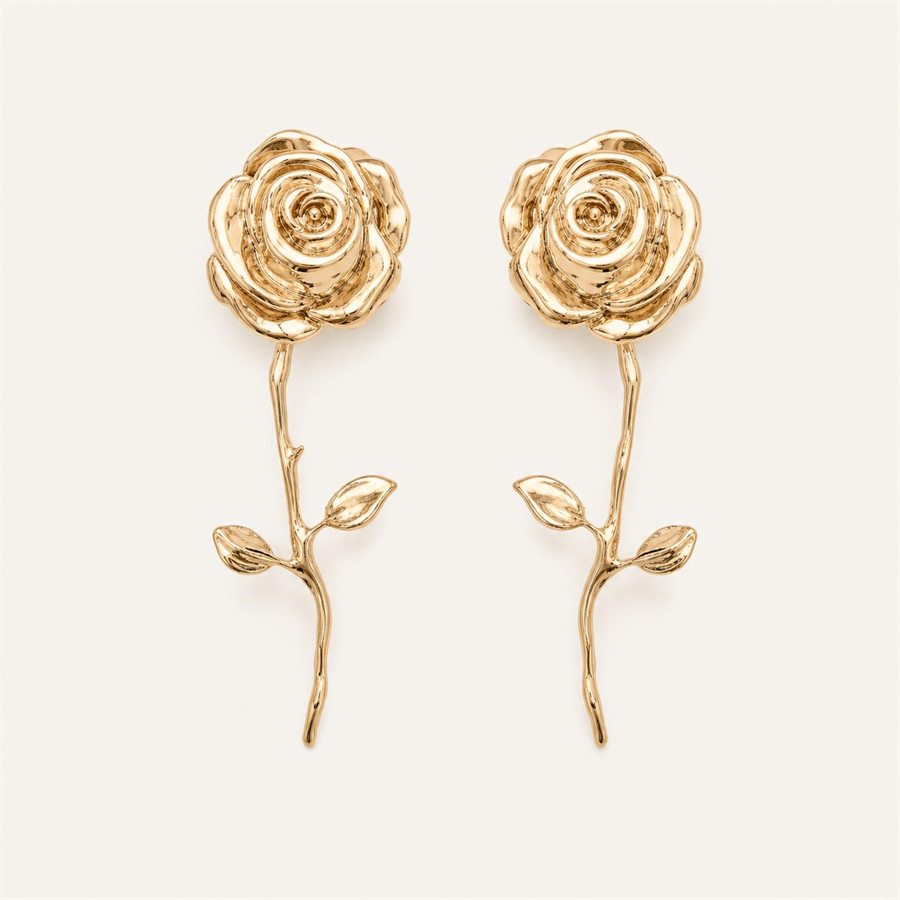 Gold rose drop earrings on a warm off-white background